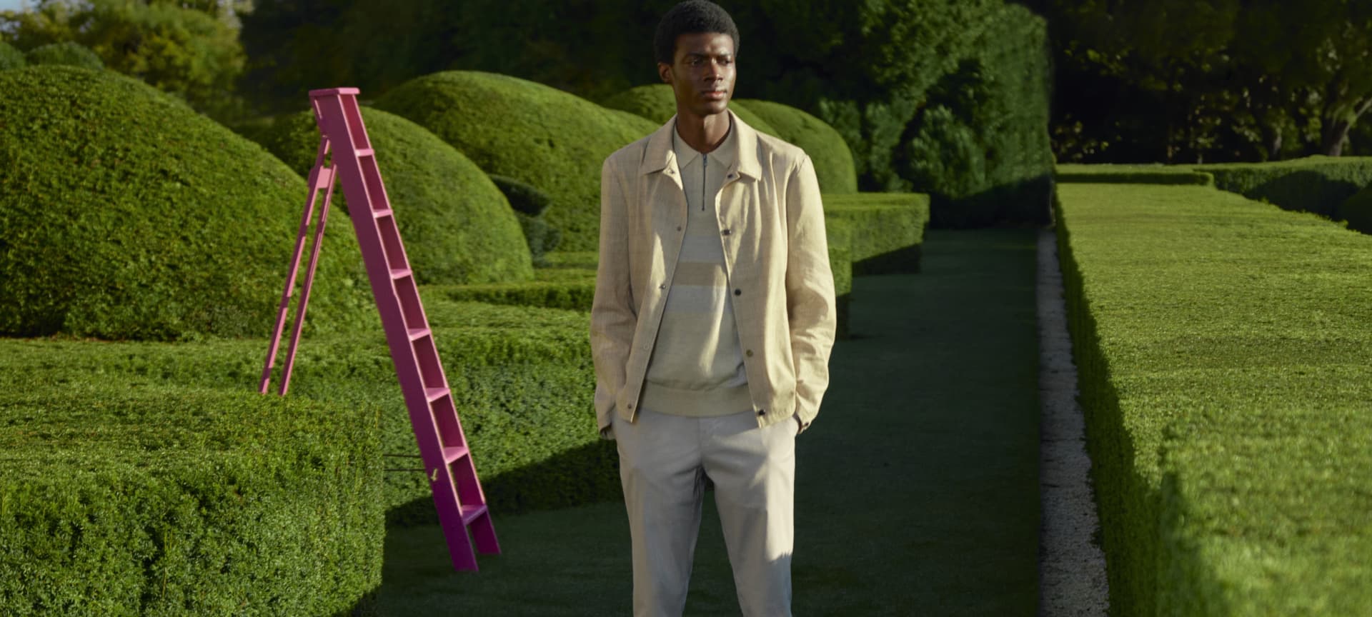 Man in beige jacket with knitted polo underneath