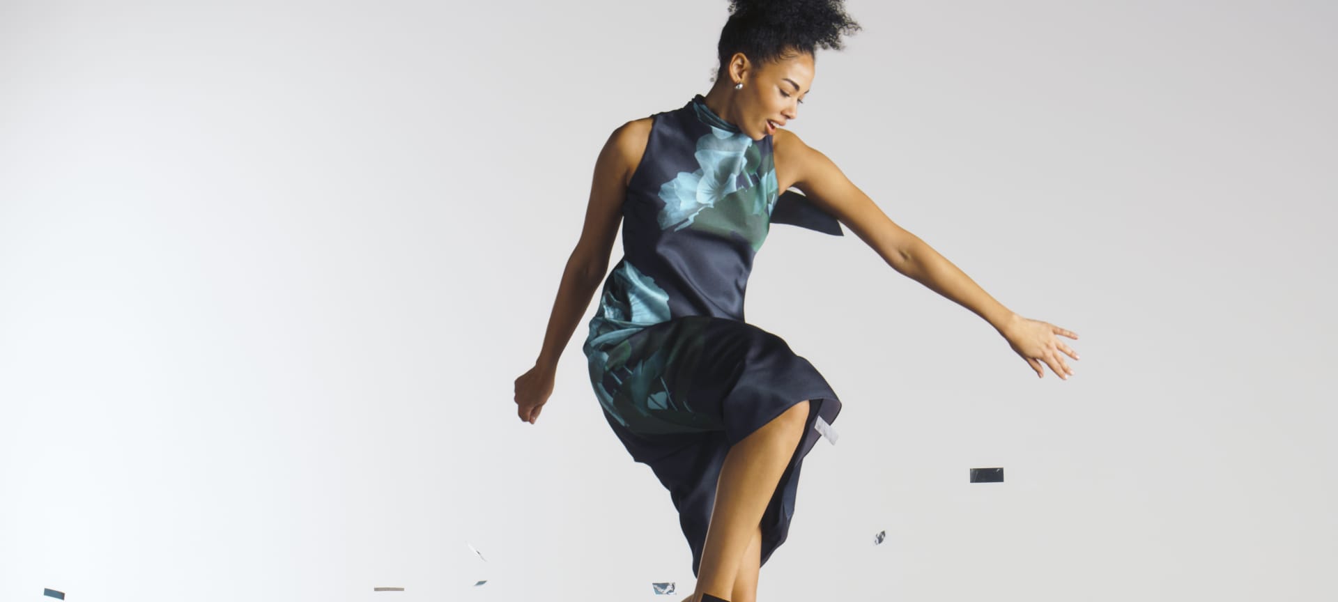 woman jumping in a floral print dres