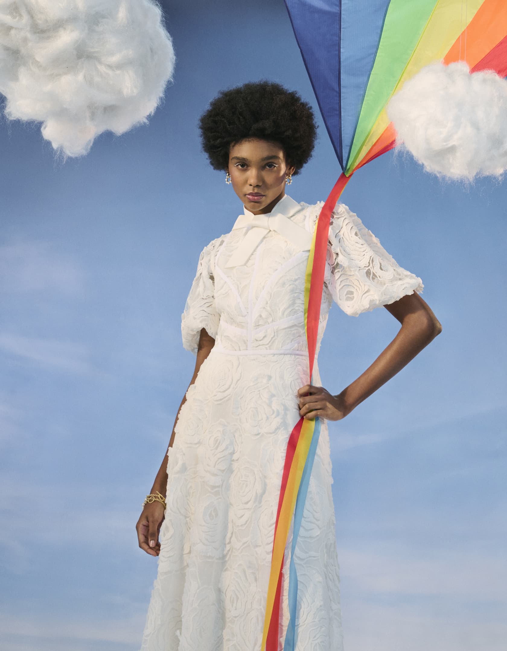 Woman in white dress holding a colourful kite