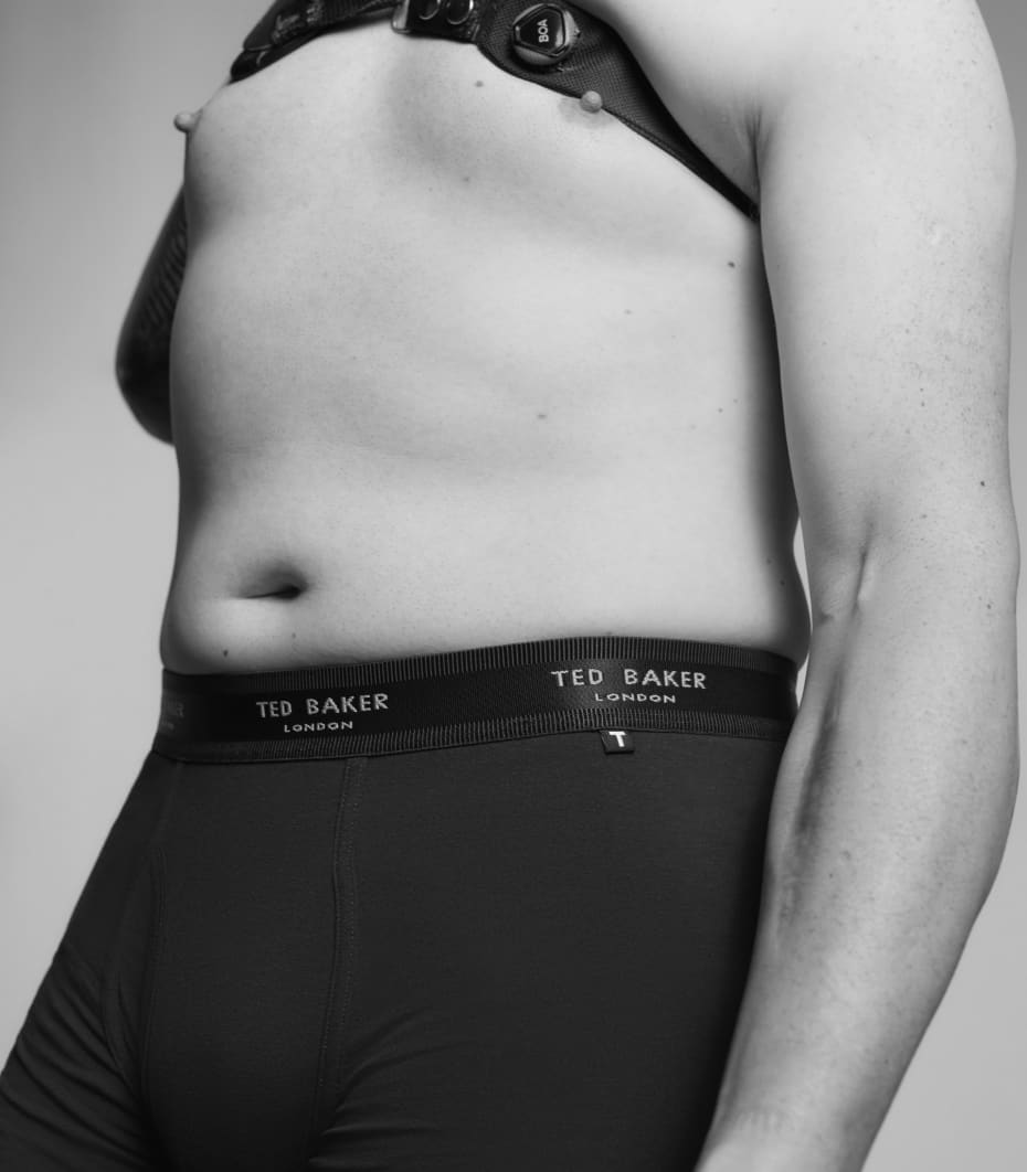 Man wearing dark underwear wearing a shoulder brace