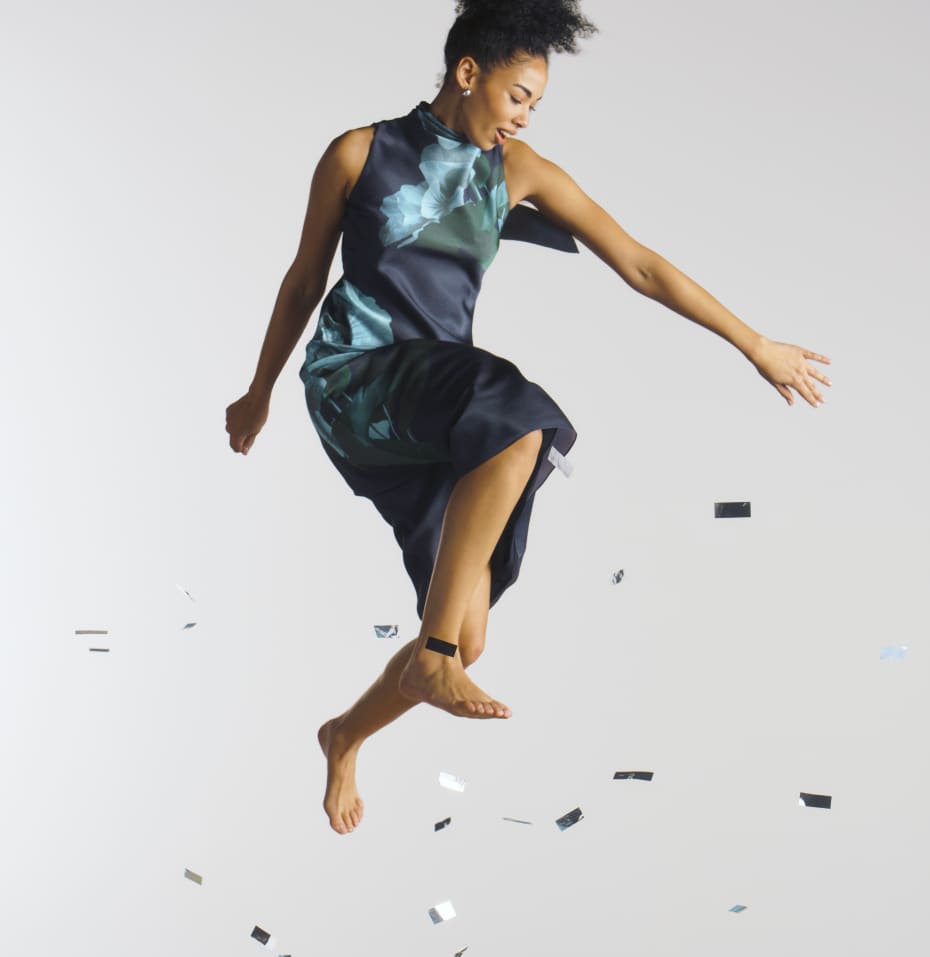 Woman jumping in a blue floral print dress