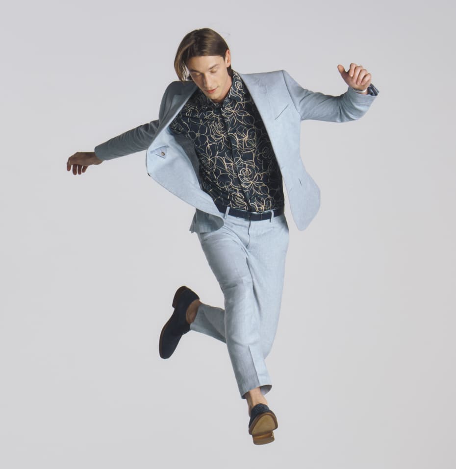Man in a light blue suit jumping