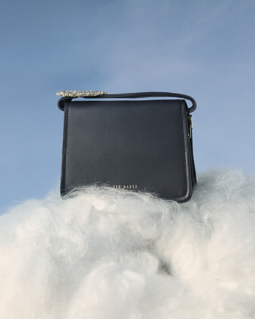 Woman's black handbag on top of clouds