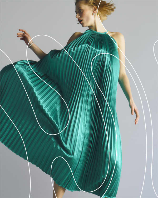 Woman jumping in a teal pleated dress