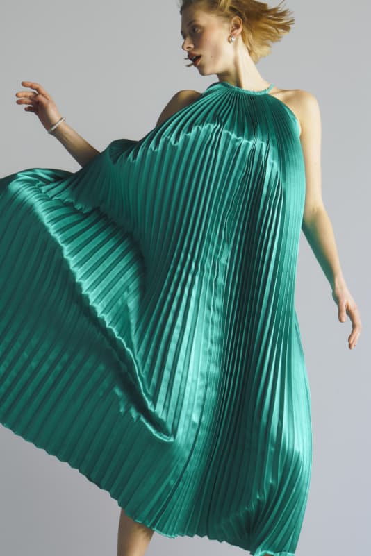 Woman in a teal pleated dress