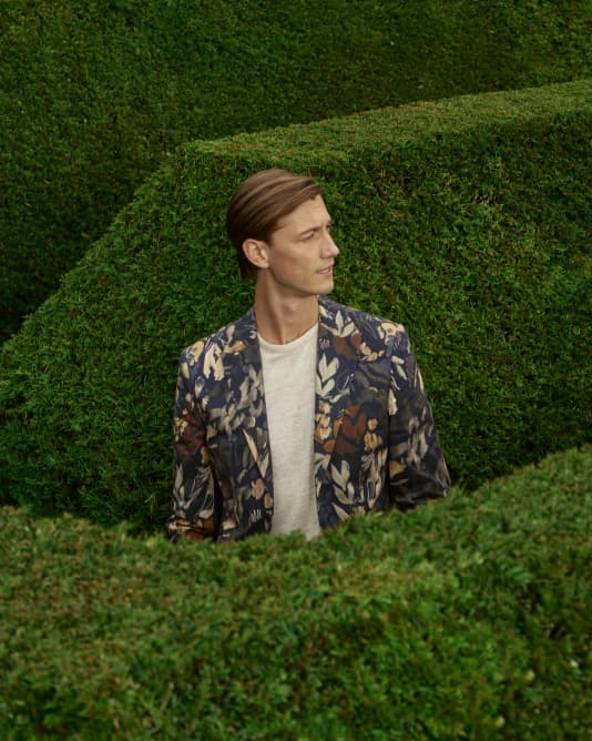 Man in a floral blazer in a maze