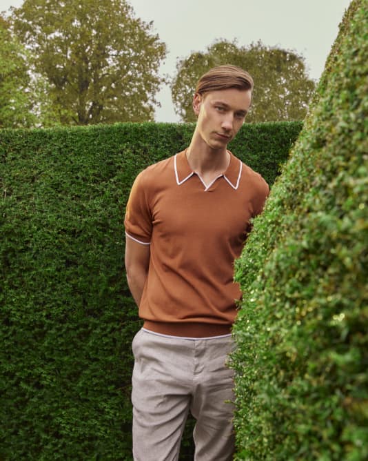 Man in a orange polo with white accents on collar