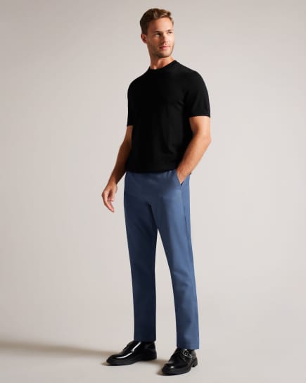Man wearing navy trousers and black short sleeve t shirt