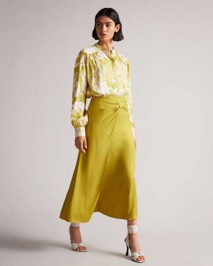 Woman in yellow print blouse with yellow midi skirt