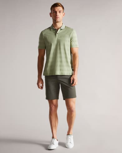 Man in green polo and green shorts