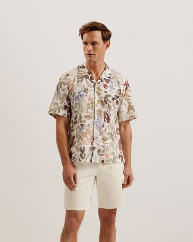 Man in foral shirt with cream shorts