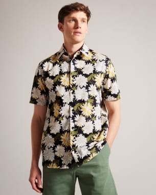 Man in floral print shirt and khaki shorts