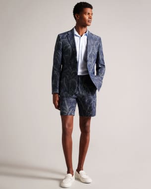 Man in navy leaf print blazer and matching shorts