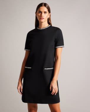 Woman in black embellished shift dress