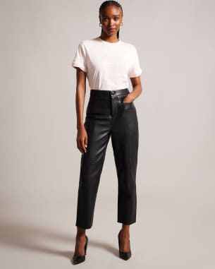 Woman in white t shirt and leather trousers