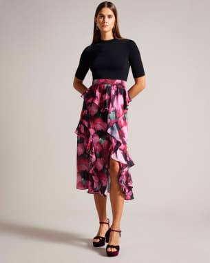 Woman in knit vest and black floral midi skirt