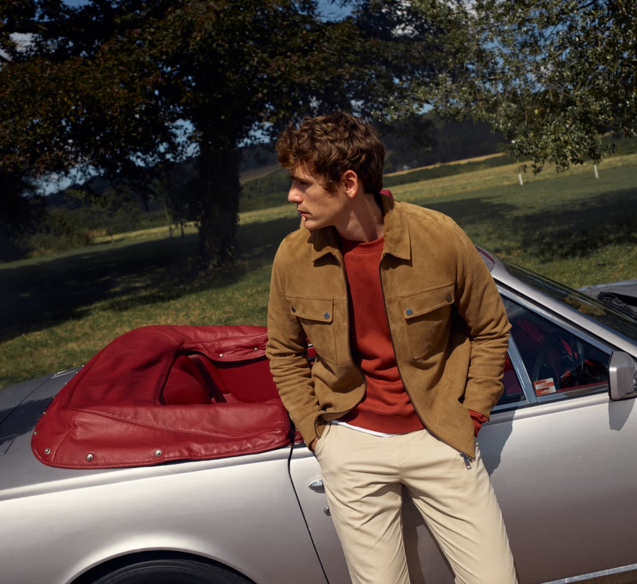 Man in a suede brown Ted Baker jacket in front of silver car
